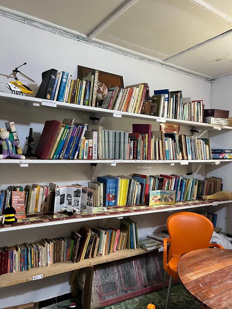 Étagères de la bibliothèque du Centre Houamla, remplies de livres en français et en anglais
