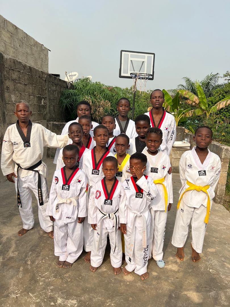 Groupe d'enfants et d'adolescents du Houamla Taekwondo Club en tenue, avec leur instructeur
